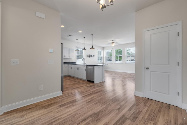 7780 Montview Rd, North Charleston, SC 29418 - kitchen with stainless steel dishwasher, a sink, a peninsula, open floor plan, and light wood-type flooring