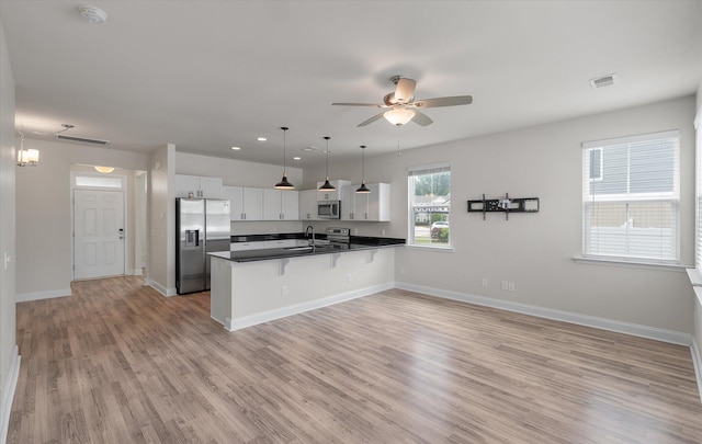 7780 Montview Rd, North Charleston, SC 29418 - kitchen featuring stainless steel appliances, a sink, dark countertops, a peninsula, and a kitchen bar