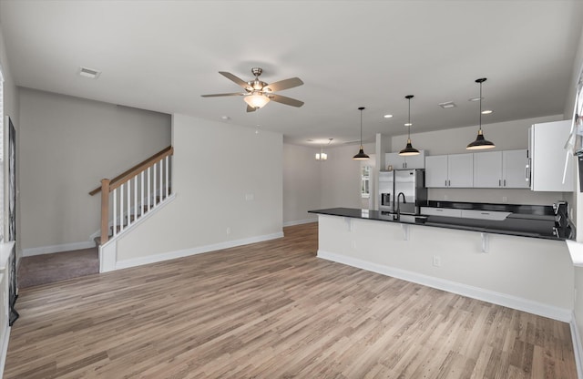 7780 Montview Rd, North Charleston, SC 29418 - kitchen with dark countertops, light wood-type flooring, a peninsula, a ceiling fan, and recessed lighting