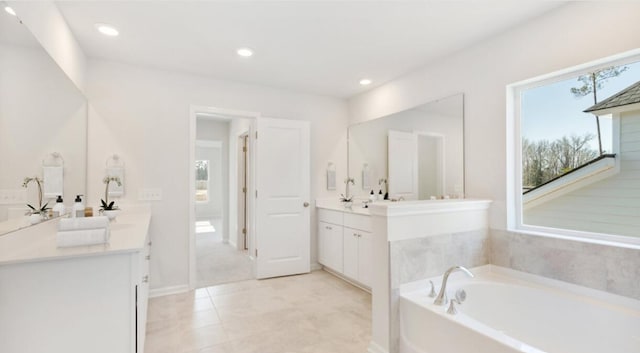 full bathroom with recessed lighting, a bath, and vanity