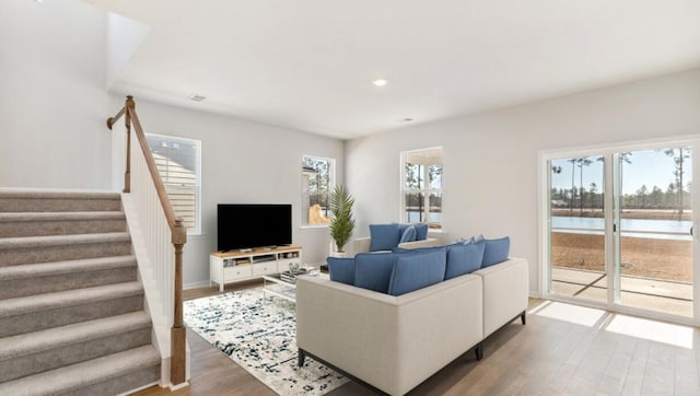 living area with recessed lighting, stairway, baseboards, and wood finished floors