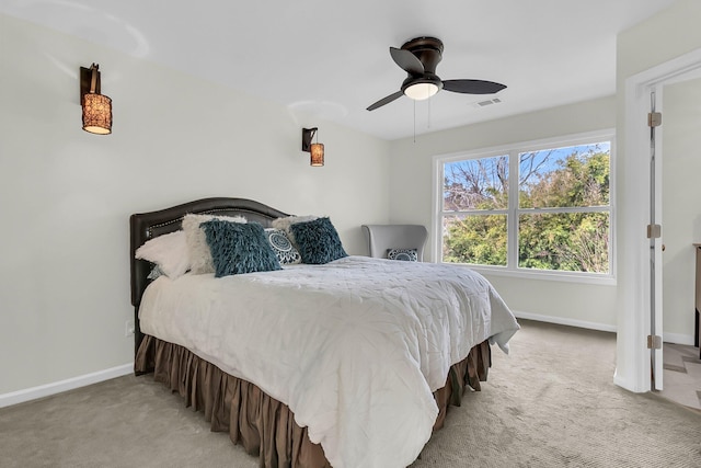 bedroom with a ceiling fan, light colored carpet, visible vents, and baseboards