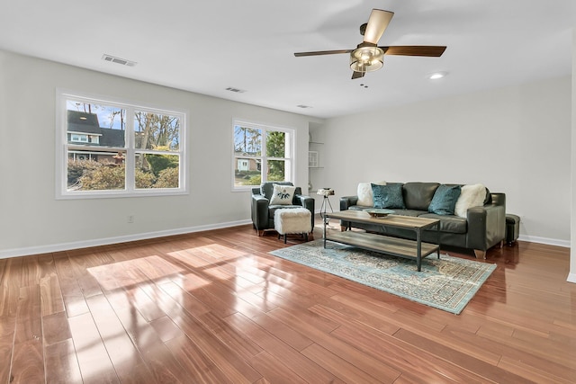 living area featuring visible vents, baseboards, and wood finished floors