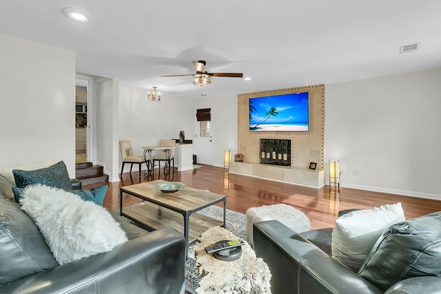 living area featuring a fireplace, visible vents, and wood finished floors