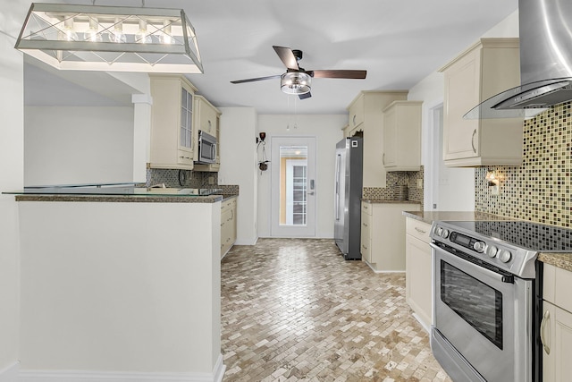 kitchen with tasteful backsplash, ceiling fan, wall chimney exhaust hood, glass insert cabinets, and stainless steel appliances