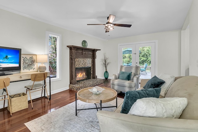 living area with baseboards, ceiling fan, a premium fireplace, dark wood-style flooring, and french doors