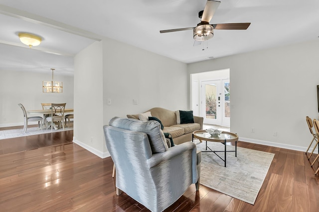 living room featuring dark wood-style floors, baseboards, and a ceiling fan