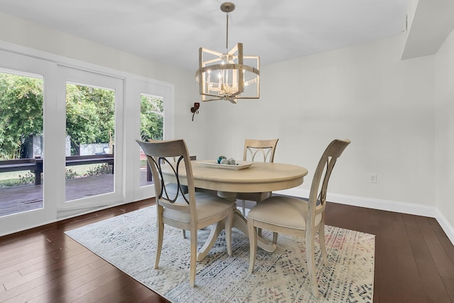 dining room with a notable chandelier, dark wood finished floors, and baseboards