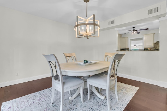 dining area featuring baseboards, visible vents, wood finished floors, and ceiling fan with notable chandelier