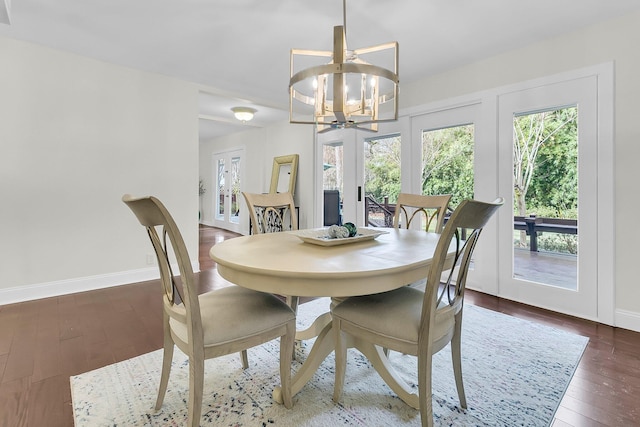 dining room with baseboards, a chandelier, and dark wood-type flooring