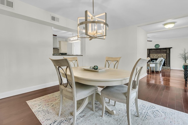 dining space featuring dark wood-style floors, visible vents, and baseboards