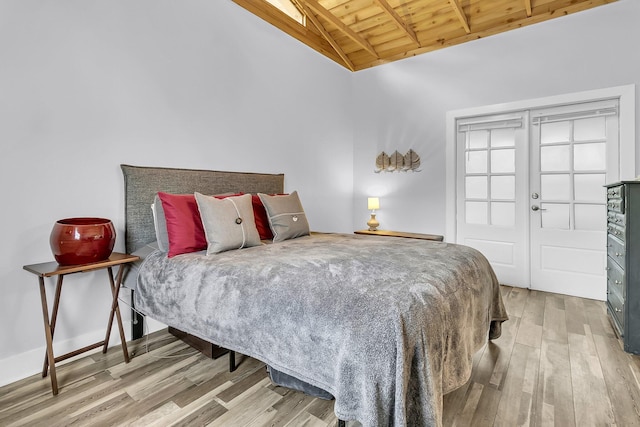 bedroom featuring vaulted ceiling with beams, wooden ceiling, light wood-type flooring, and baseboards