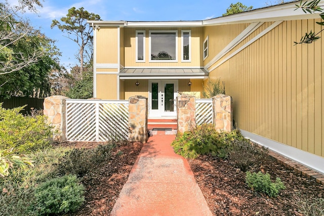 view of front of property with a standing seam roof, metal roof, and a fenced front yard