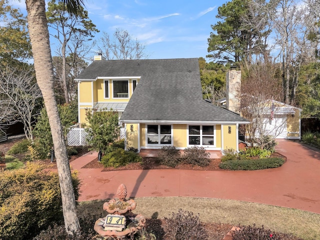 view of front of property featuring a shingled roof, a chimney, and metal roof