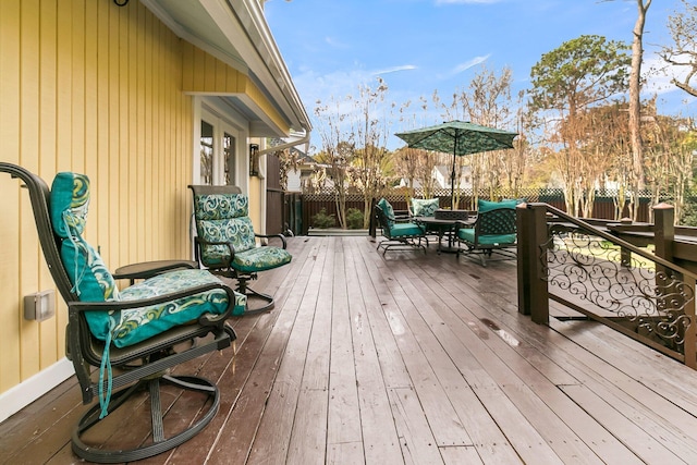 deck with outdoor dining space and fence