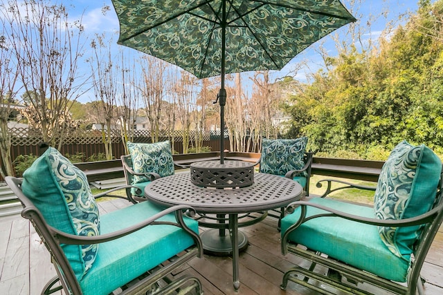 deck featuring outdoor dining area and fence