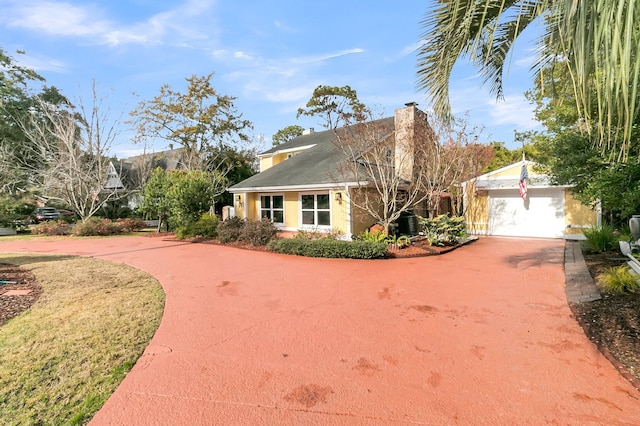 view of front facade with driveway and a chimney