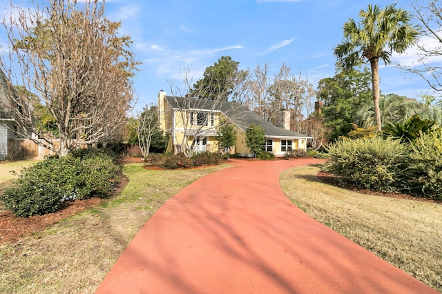 view of front of home with a front yard and a chimney