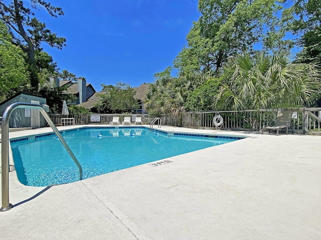 community pool featuring a patio area and fence