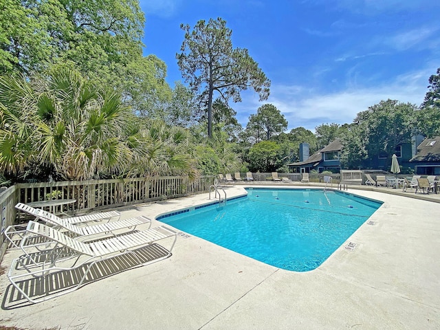 pool with a patio and fence