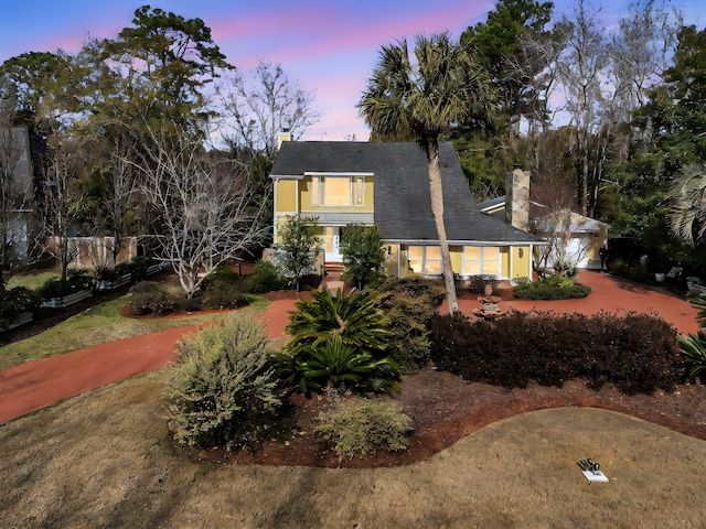 view of front of house featuring driveway and a chimney