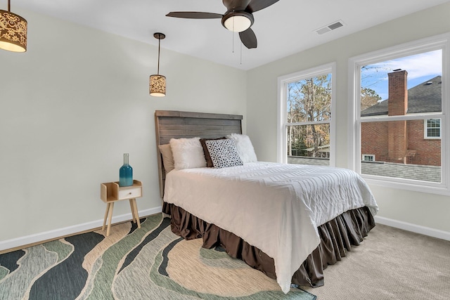 bedroom with a ceiling fan, carpet flooring, visible vents, and baseboards