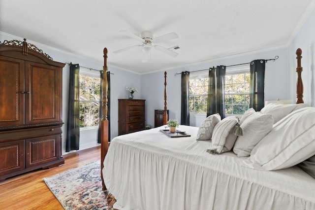 bedroom with ornamental molding, light wood-type flooring, and ceiling fan