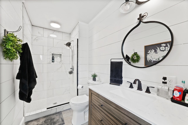 bathroom with vanity, toilet, and tiled shower