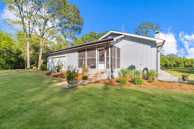 view of side of home featuring a sunroom and a yard