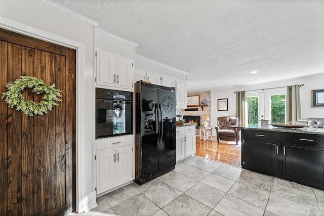 kitchen with a stone fireplace, white cabinets, black appliances, a textured ceiling, and ornamental molding