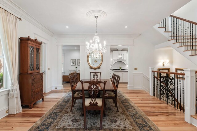 dining space featuring light wood-type flooring, a chandelier, recessed lighting, and crown molding
