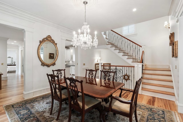 dining area featuring light wood finished floors, stairway, baseboards, crown molding, and recessed lighting