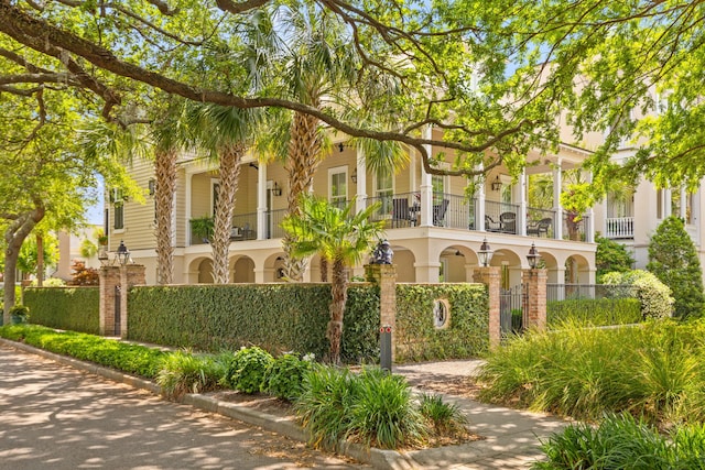 view of front facade with a balcony, a fenced front yard, and stucco siding