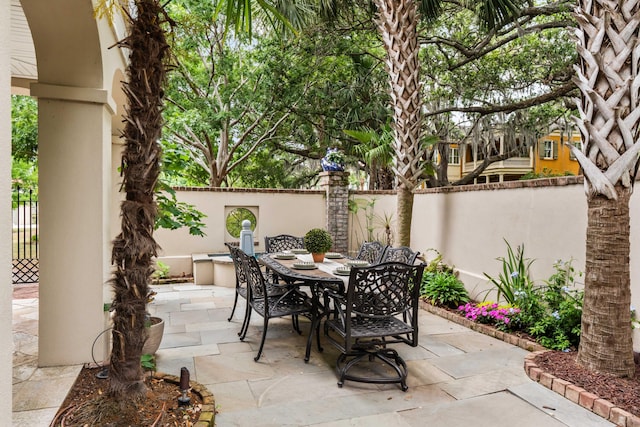 view of patio with outdoor dining space and fence
