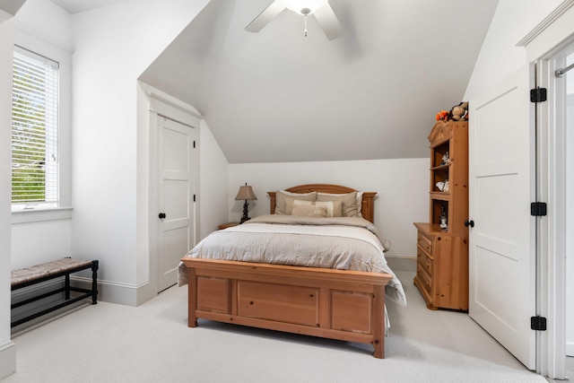 bedroom with lofted ceiling, light carpet, a ceiling fan, and baseboards