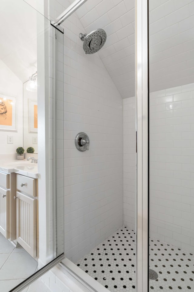 full bath featuring vaulted ceiling, a stall shower, and vanity