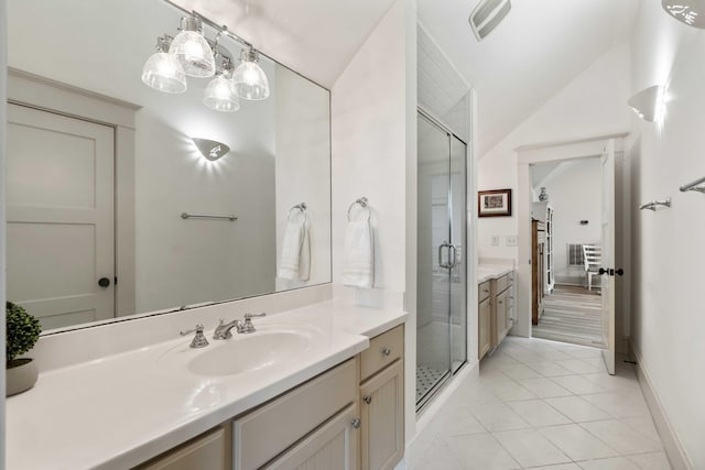 bathroom featuring vanity, a stall shower, vaulted ceiling, tile patterned floors, and baseboards
