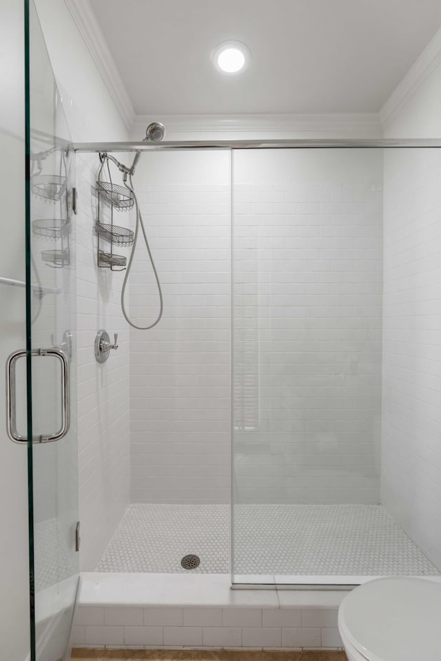 full bathroom with crown molding, a stall shower, and toilet
