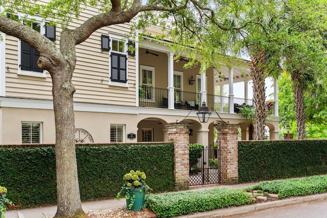 view of front facade featuring a balcony, a fenced front yard, and stucco siding