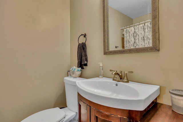 bathroom with vanity, wood-type flooring, and toilet