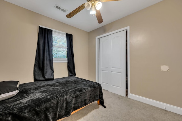 carpeted bedroom with ceiling fan and a closet