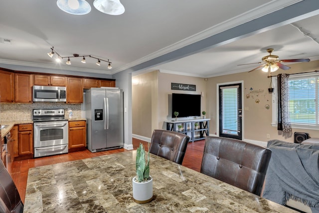 kitchen featuring light stone countertops, crown molding, and stainless steel appliances