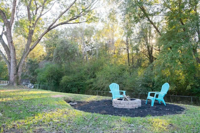 view of yard with an outdoor fire pit and fence