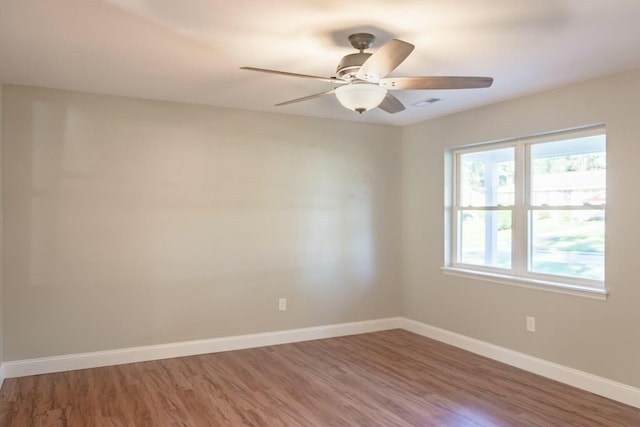 spare room with a ceiling fan, baseboards, and wood finished floors