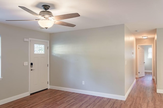 foyer entrance with light wood-type flooring, baseboards, and ceiling fan