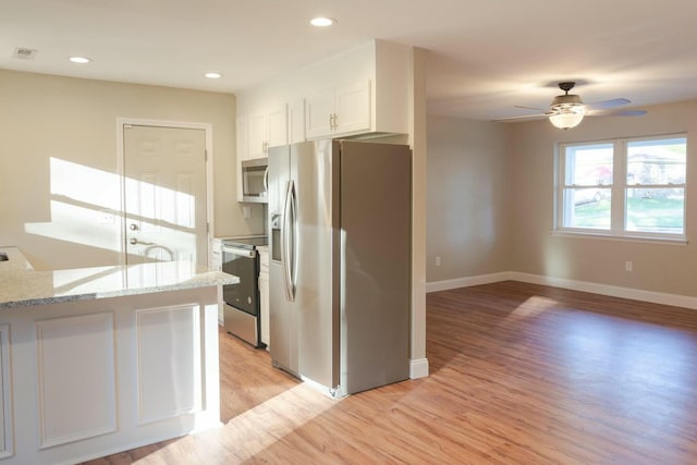 kitchen with visible vents, white cabinetry, stainless steel appliances, light wood-style floors, and ceiling fan