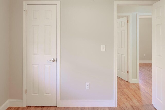 unfurnished bedroom with light wood-style flooring and baseboards