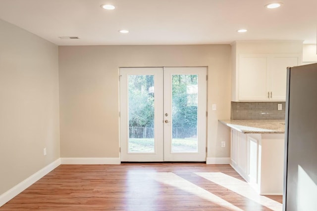 doorway featuring french doors, baseboards, and light wood finished floors