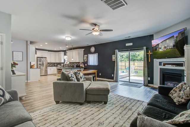 2021 Asher Loop, Summerville, SC 29485 - living area with baseboards, ceiling fan, light wood-style flooring, recessed lighting, and a glass covered fireplace