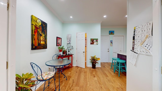 hallway with light wood-style floors, baseboards, ornamental molding, and recessed lighting